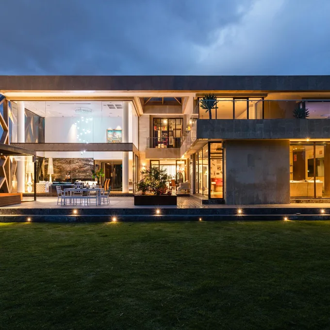Contemporary glass villa illuminated at dusk